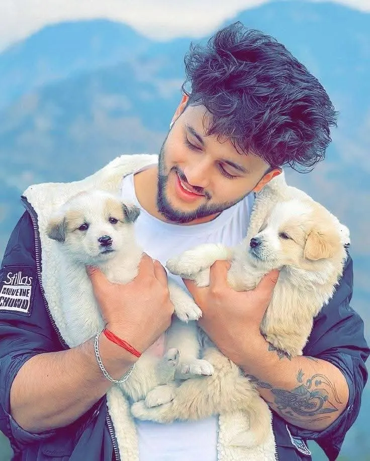 a man holding two small, fluffy puppies