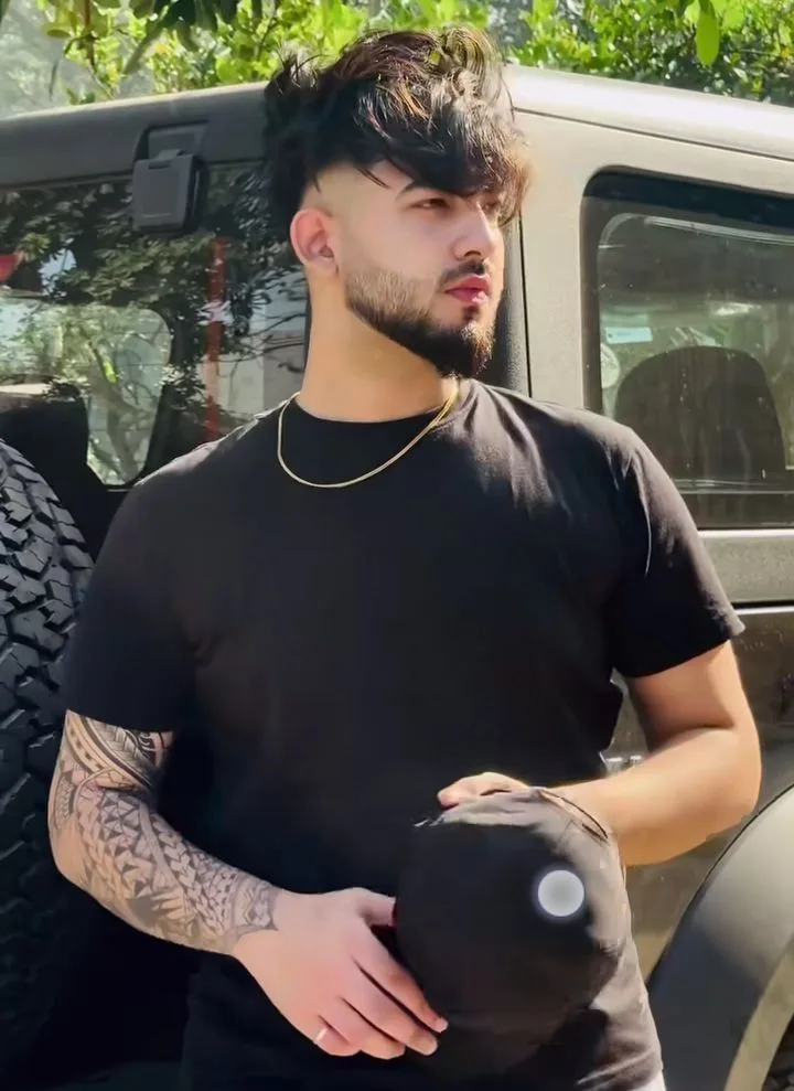 man standing in front of a silver Jeep Wrangler