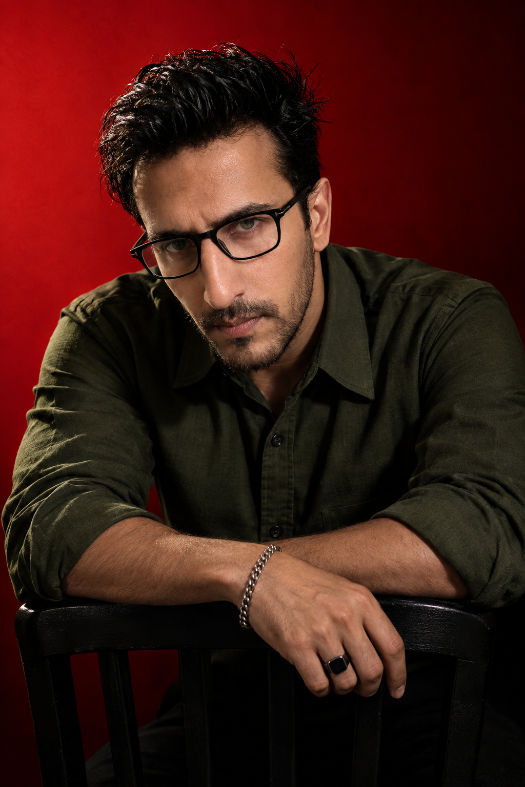 A dramatic, high-contrast studio portrait of a man with dark messy