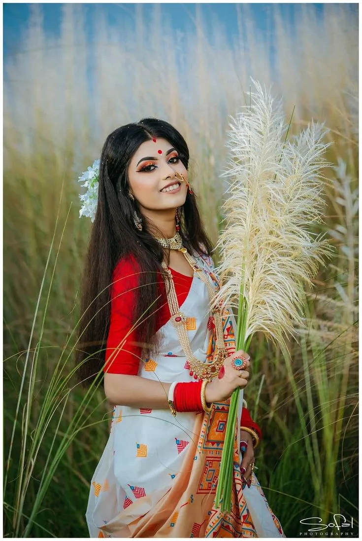 Festive Bengali Durga Puja Portrait of Young Woman in White Silk Saree Holding Kash Phool
