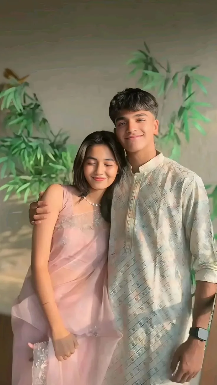 Affectionate Outdoor Portrait of Young Couple in Pastel Ethnic Attire with Bamboo Backdrop