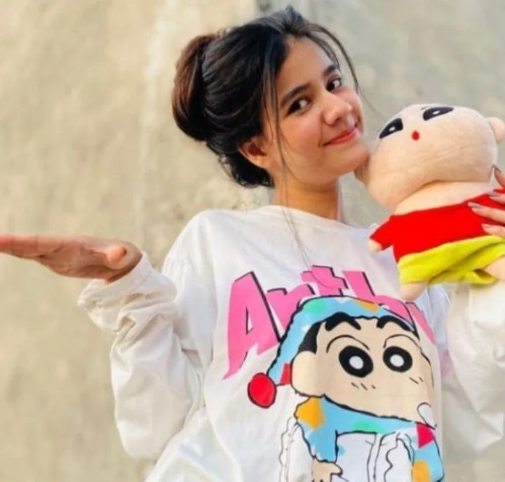 Playful Candid Portrait of Young Indian Woman Holding Shin-chan Plushie