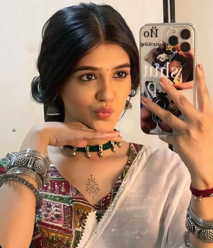 Playful Festive Mirror Selfie of Young Woman in White Saree and Traditional Silver Jewelry