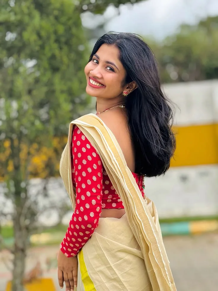 Candid Outdoor Portrait of Indian Woman in Traditional Kasavu Saree and Red Blouse
