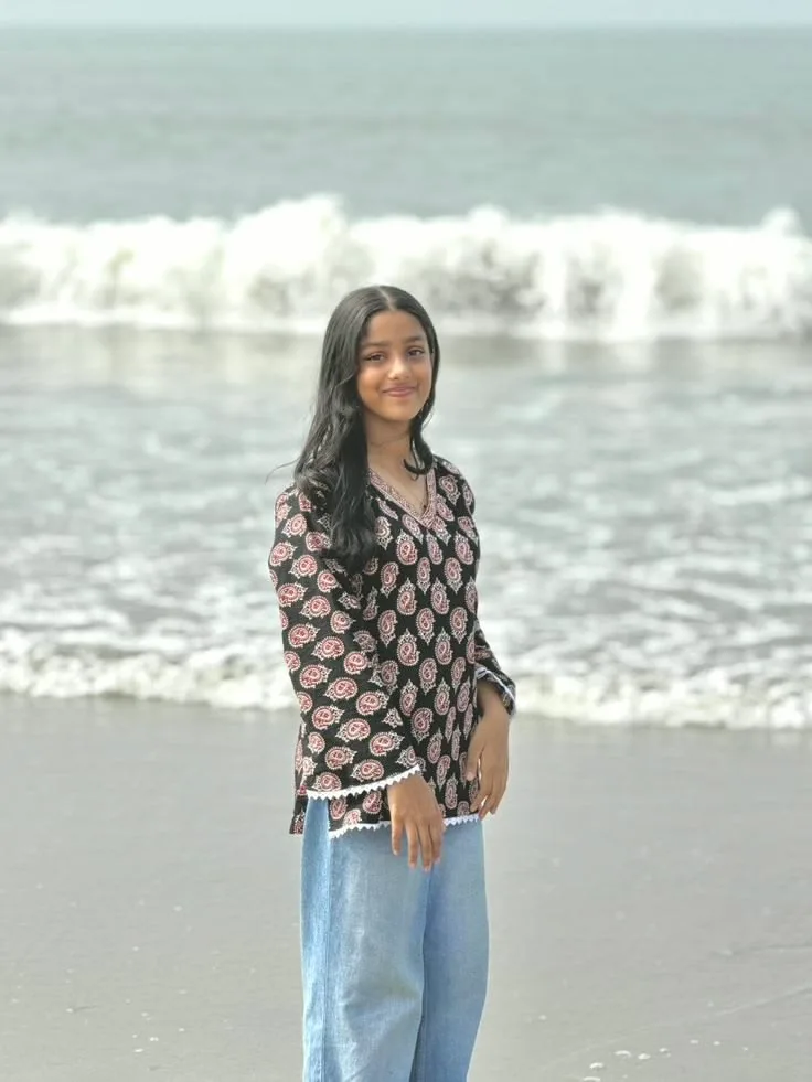 Candid Young Woman in Paisley Print Kurti on Sandy Beach with Ocean Waves