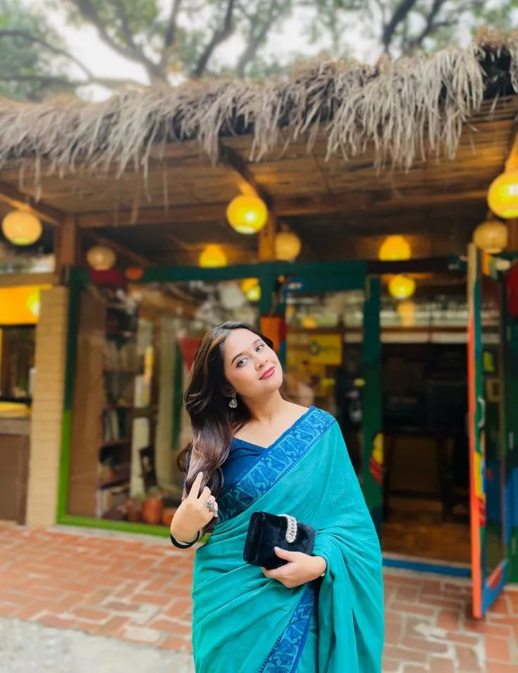 Candid Outdoor Portrait of Young Indian Woman in Cyan Saree at Rustic Cafe