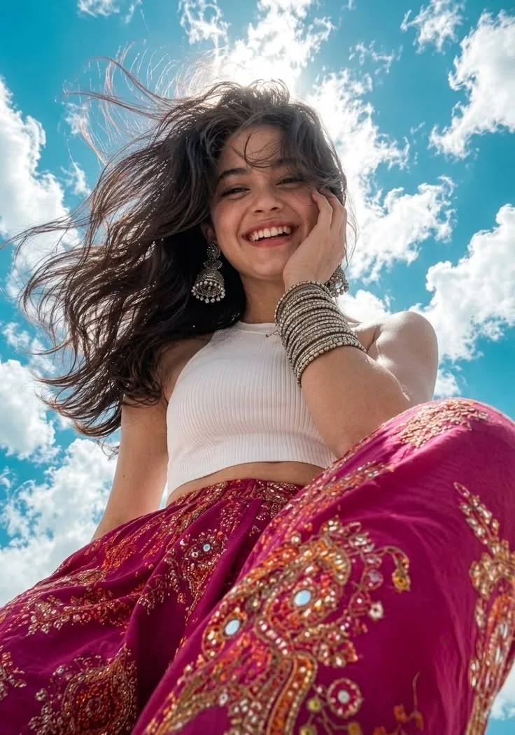 Candid Smiling Young Woman in Magenta Embroidered Lehenga and White Crop Top Under Bright Blue Sky