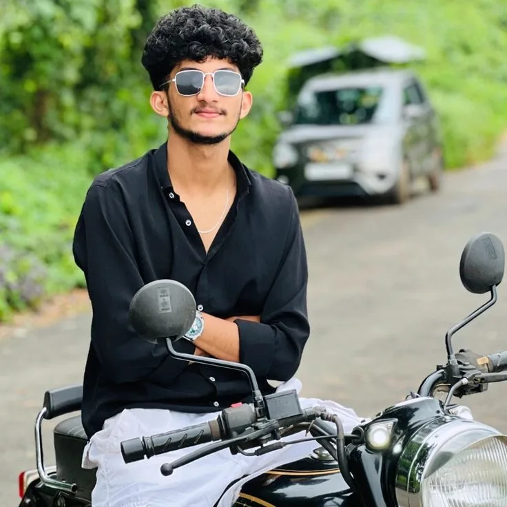 Candid Young Man in Black Shirt with Sunglasses Seated on Vintage Motorcycle