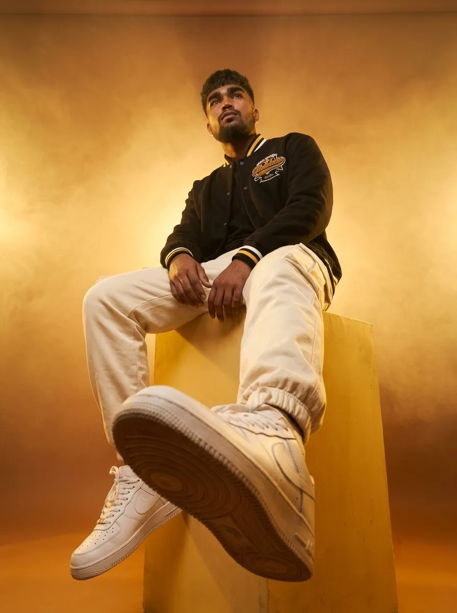 Dynamic Low-Angle Studio Male Portrait in Varsity Jacket & White Sneakers Prompt