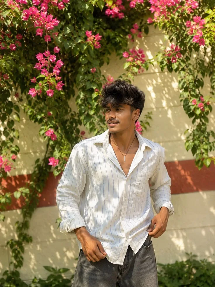 Candid Young Man in White Striped Linen Shirt Under Bougainvillea Flowers