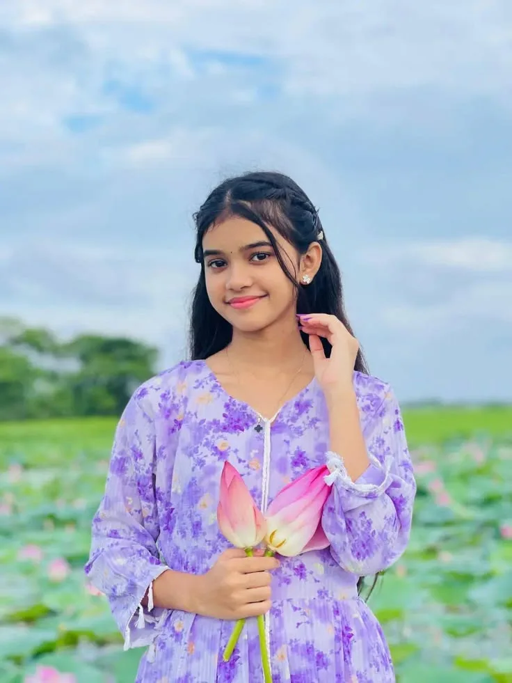 Candid Outdoor Portrait of Young Girl in Lavender Floral Kurti Holding Pink Lotus Blossoms