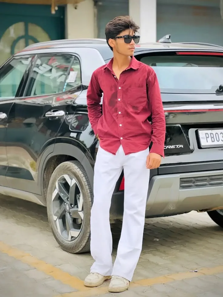 Candid Young Man in Maroon Shirt Leaning against Black SUV