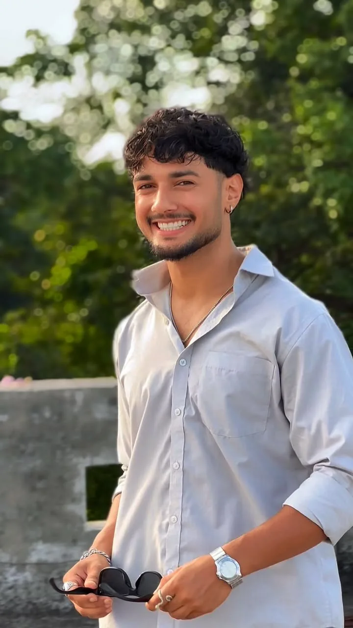 Candid Outdoor Rooftop Portrait of Smiling Young Man with Textured Fringe in Open-Collar Shirt