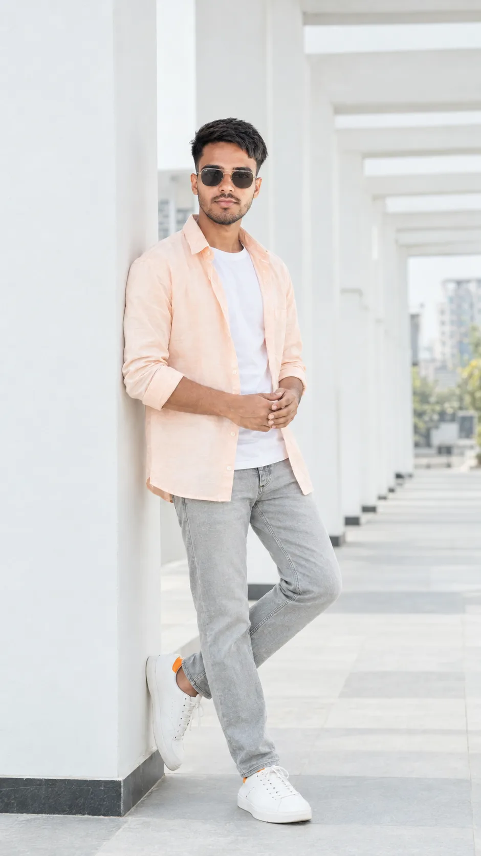 Full-body fashion portrait of a handsome young Indian man standing casually