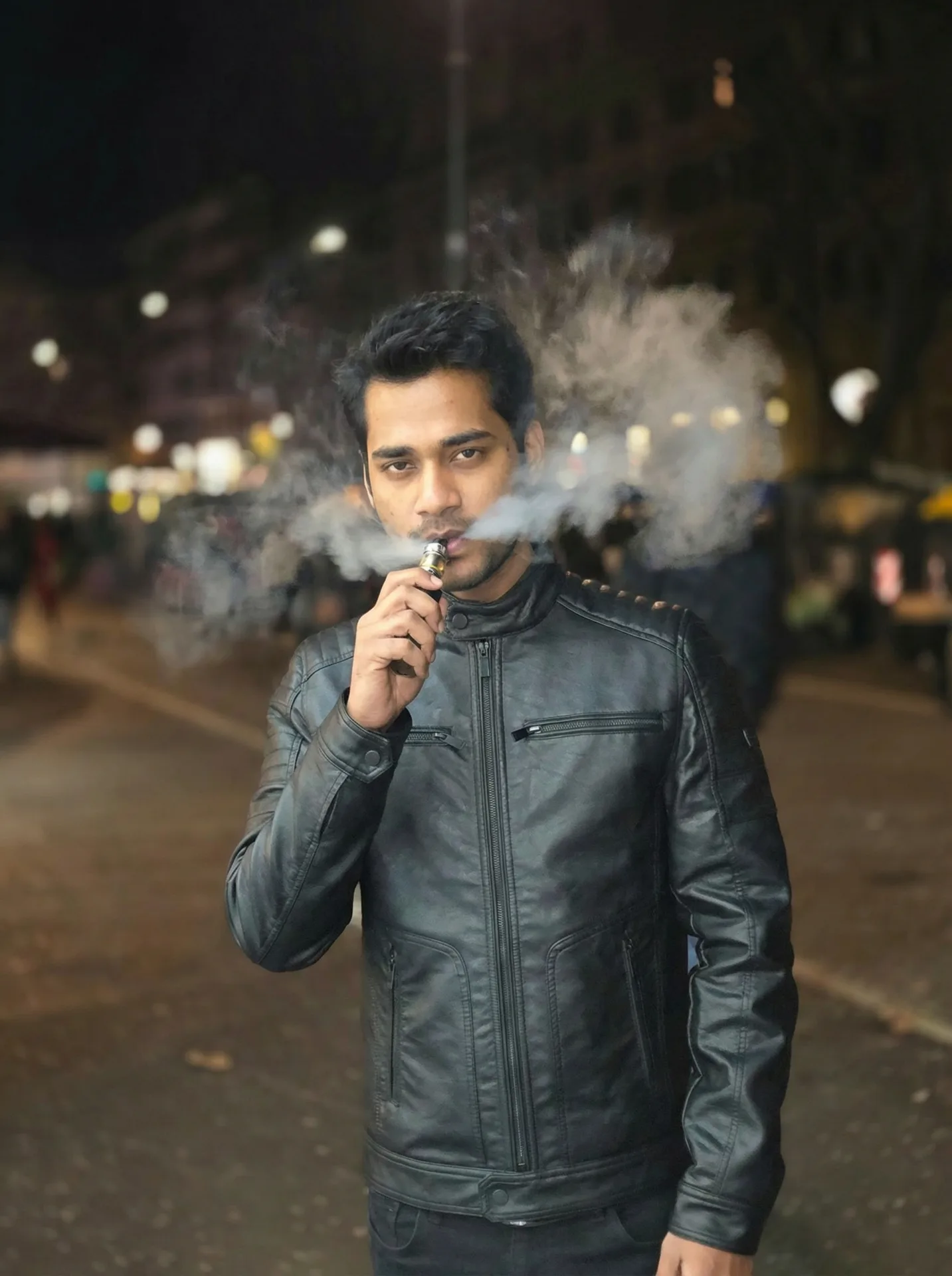 A young South Asian man with short styled black hair and